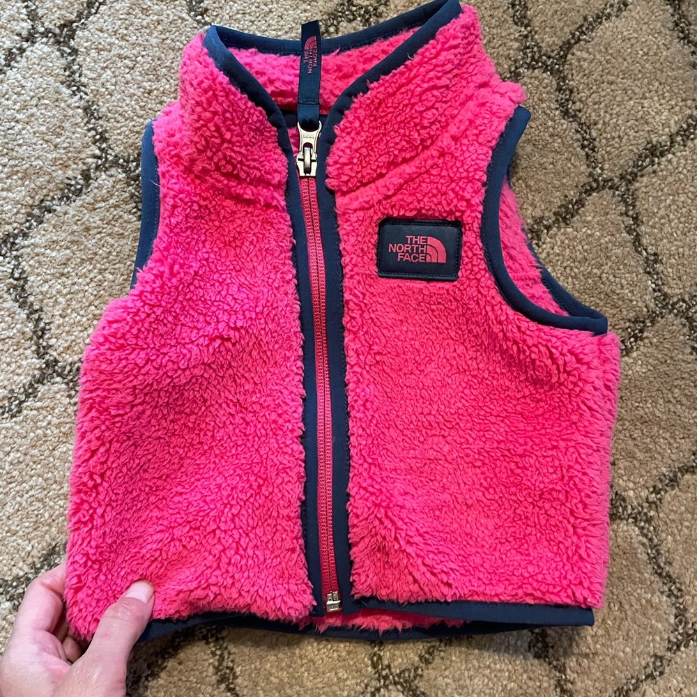 North Face pink vest with navy trim 0-3M, great condition.